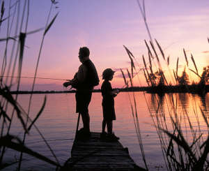 adult and child fishing at sunset