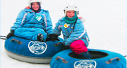 Two kids snow tubing