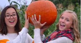 Two girls holding a pumpkin