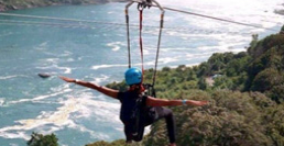 person zip lining over a waterfall