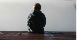 Boy sitting on the edge of a dock