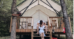 A couple hugging in front of a tent