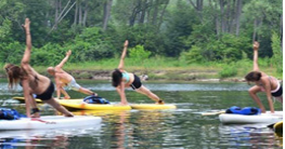 A group of people doing yoga on paddle boards