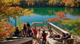 People standing on a deck overlooking a lake and trees