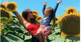 Women and child standing in a sunflower field 