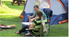 Two people sitting in chairs outside of a tent