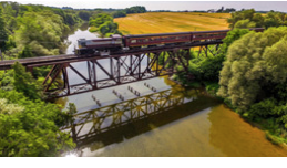 Train crossing a body of water on a bridge