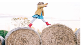 Girl walking on a hay stack