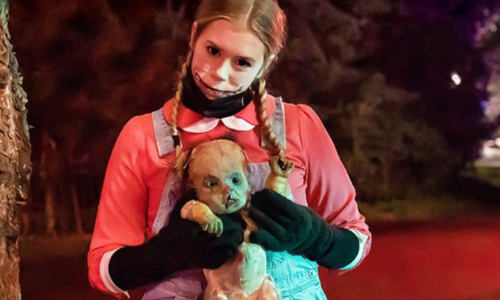 A scary girl holding a teddy bear