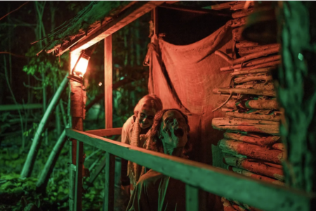 Two zombies sitting on a porch of a house