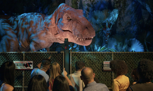 A crowd of people looking at a dinosaur