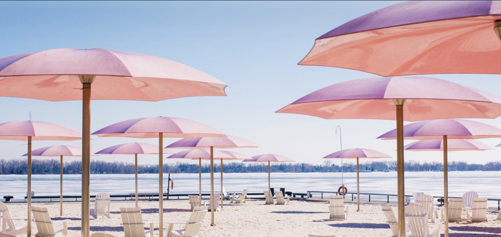 pink umbrellas on a white sand beach