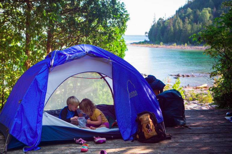 Family beach camping in Ontario with Children in a tent with beach views
